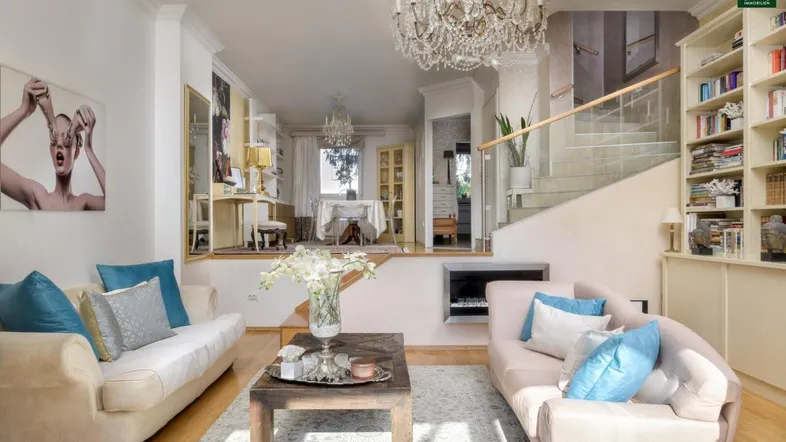 Geräumiges Wohnzimmer mit elegantem Kronleuchter, Parkettboden und offenem Übergang zum Essbereich.