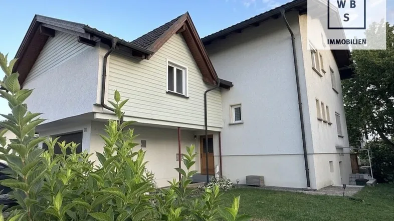 Ansicht des Einfamilienhauses von außen mit gepflegtem Garten und traditioneller Architektur.