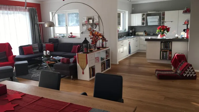 Geräumiger offener Wohn- und Essbereich mit Holzboden und moderner Küche, festlich dekoriert.