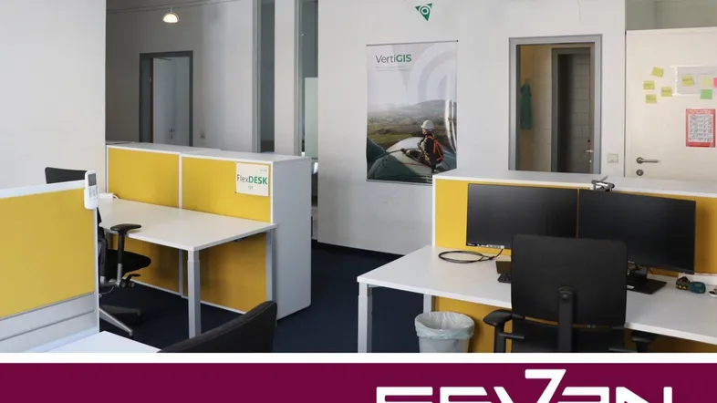Helles Büro mit mehreren Arbeitsplätzen, gelben Trennwänden und moderner Ausstattung für eine angenehme Arbeitsumgebung.