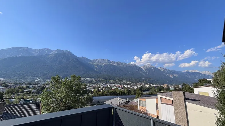 Panoramablick vom Balkon auf die majestätischen Berge und die darunterliegende Stadt.