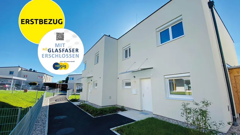Moderne Neubauten mit heller Fassade und Glasfaseranschluss, bereit für den Erstbezug.