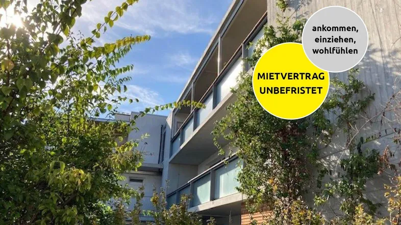 Moderne Wohnanlage mit begrünten Fassaden und Balkonen unter blauem Himmel.