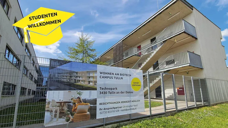 Modernes Wohngebäude mit Außenfluren und Werbebanner für Studentenwohnungen.