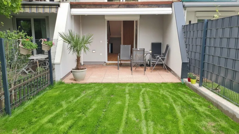 Gepflegter Gartenbereich mit kleiner Terrasse und Sitzgelegenheiten, ideal für entspannte Stunden im Freien.