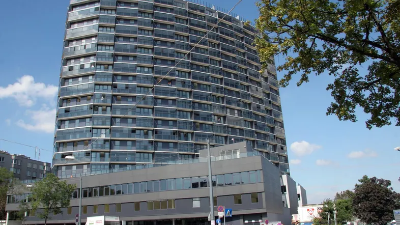 Modernes Hochhaus mit vielen Etagen und einer markanten Glasfassade in städtischer Umgebung.