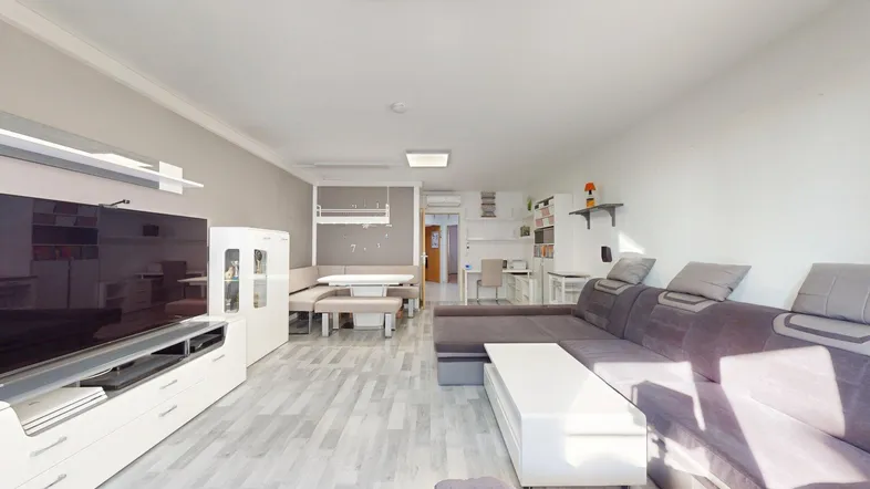 Helles Wohn- und Esszimmer mit modernem Sofa, Esstisch und hellem Laminatboden.