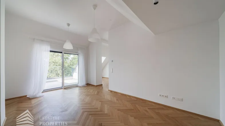 Helles Wohnzimmer mit Fischgrätparkett und Zugang zu einem Balkon oder einer Terrasse.
