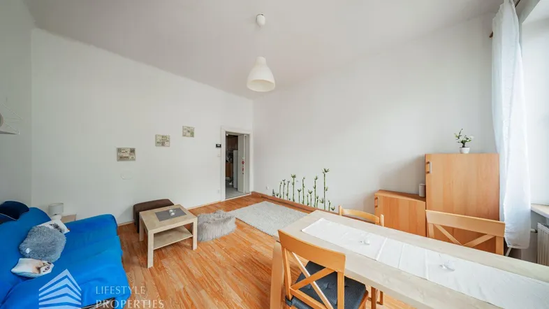 Helles Wohn- und Esszimmer mit Holzfußboden und einfacher Einrichtung.
