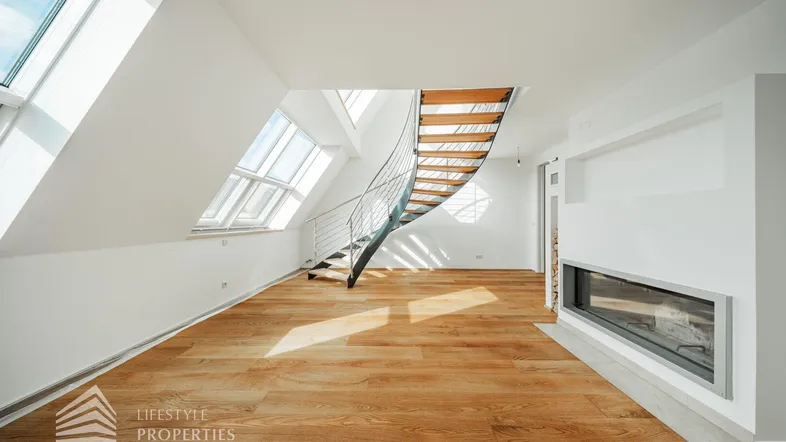 Helles Dachgeschoss-Wohnzimmer mit Holzboden, modernen Dachfenstern und integriertem Kamin.