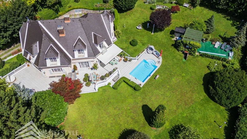 Luftaufnahme der luxuriösen Villa mit großem Garten, Pool und weitläufigen Terrassenbereichen.