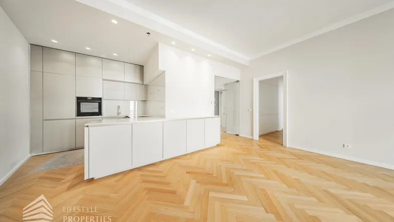 Moderner offener Wohnbereich mit integrierter Küche, Fischgrätparkett und viel Platz.