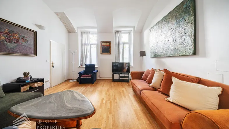 Helles Wohnzimmer mit Holzboden, bequemen Sofas und Kunstwerken an den Wänden.