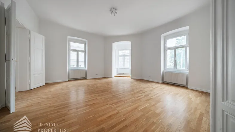 Helles, geräumiges Wohnzimmer mit Fischgrätparkett und hohen Fenstern, bereit zur individuellen Gestaltung.