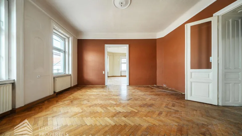 Geräumiges Zimmer mit Fischgrätparkett und hohen Decken, bereit für die individuelle Gestaltung.