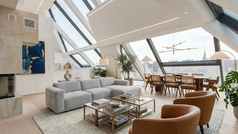 Offener Wohn- und Essbereich mit schrägen Glasdächern, Holzboden und eleganten Möbeln.