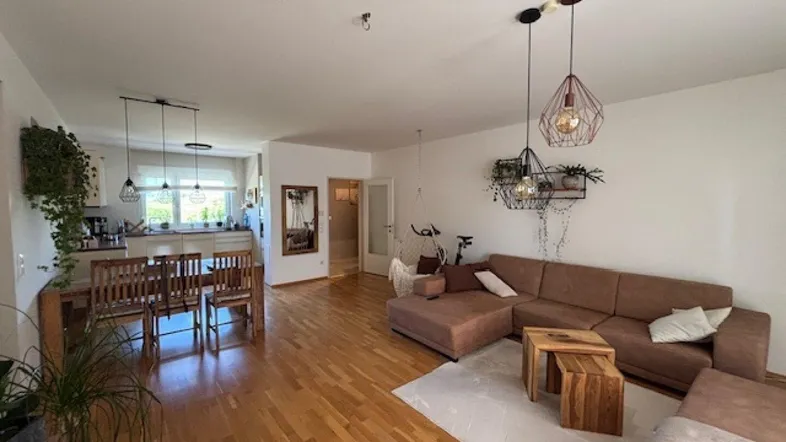 Geräumiger offener Wohn- und Essbereich mit hellem Parkettboden und moderner Einrichtung.