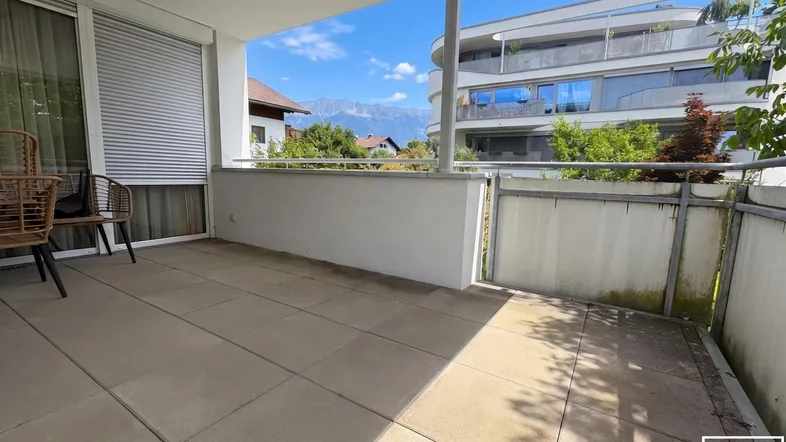 Große geflieste Terrasse mit Bergblick und Platz für Gartenmöbel, ideal zum Entspannen im Freien.