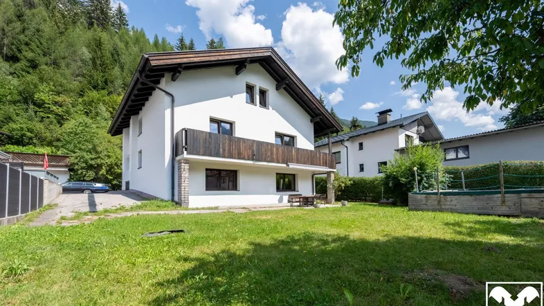 Freistehendes Haus mit großem Garten, Balkon und Bergblick in grüner Umgebung.