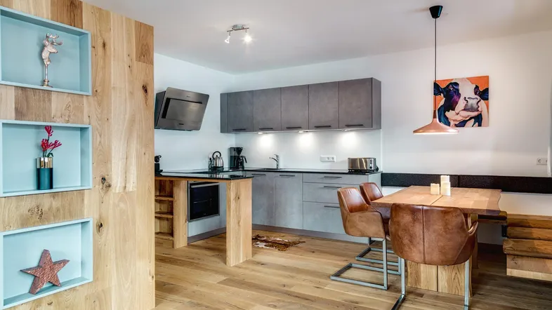 Moderne offene Küche mit Essbereich, Holzelementen und zeitgemäßer Dekoration.