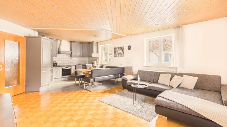 Heller offener Wohn- und Essbereich mit Holzbalkendecke und Parkettboden, ideal für geselliges Beisammensein.