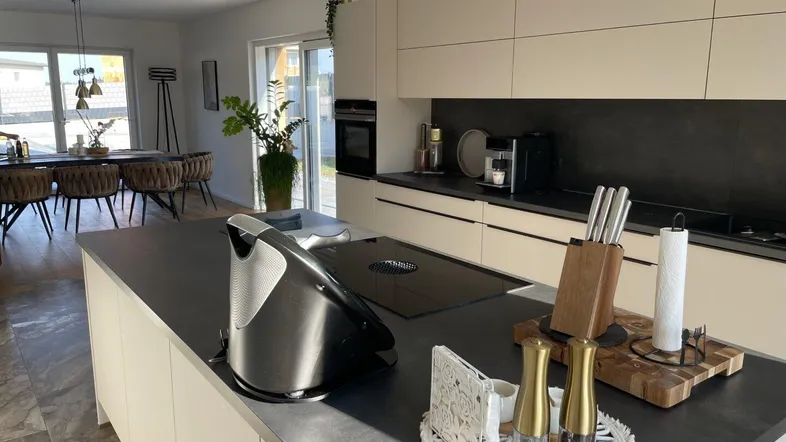 Moderne offene Küche mit Kochinsel und angrenzendem Essbereich, hell und einladend gestaltet.