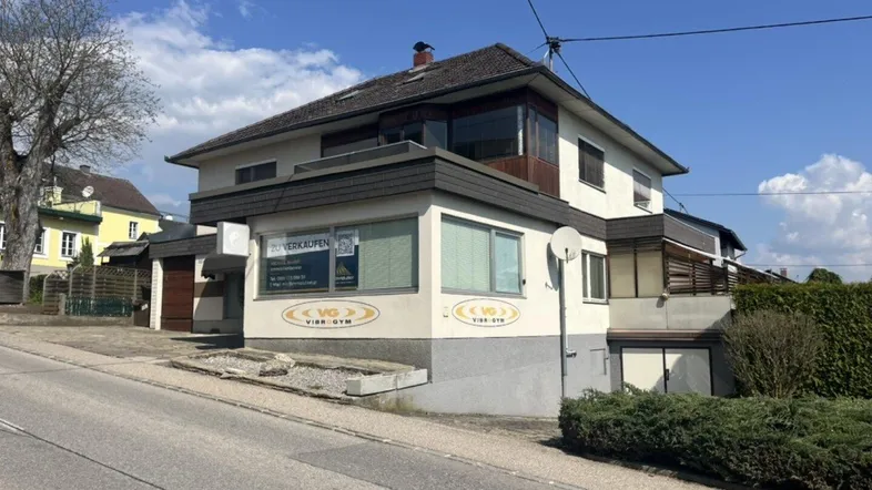 Seitenansicht des Gebäudes mit kommerziellen Flächen und Wohnbereich im Obergeschoss.