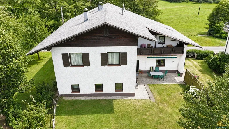 Luftaufnahme eines Einfamilienhauses mit Terrasse und umliegendem Garten in ländlicher Umgebung.