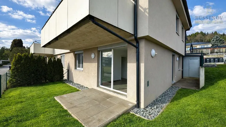 Außenansicht des Gebäudes mit kleiner Terrasse und Zugang zum Gartenbereich.