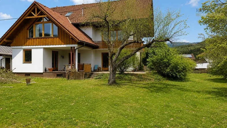 Großzügiges Einfamilienhaus mit weitläufigem Garten und Blick auf die umliegende Natur.