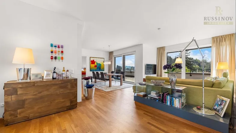Geräumiger, offener Wohn- und Essbereich mit Holzboden und Zugang zur Dachterrasse.