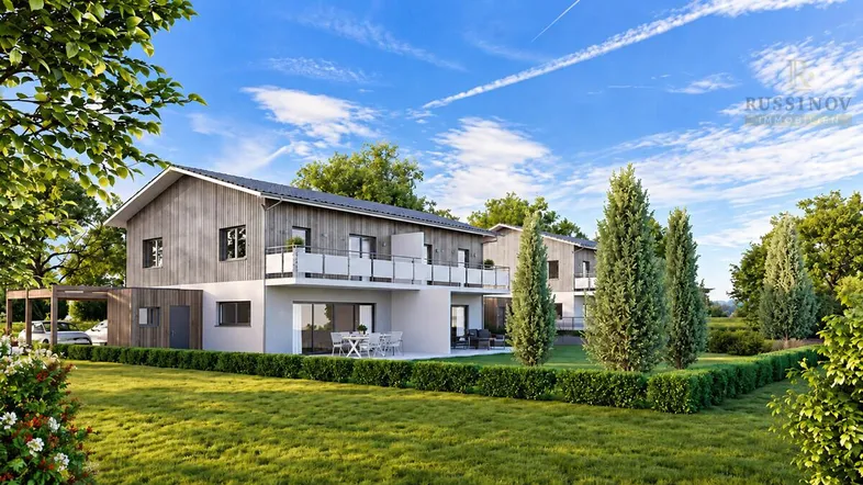 Moderne Doppelhäuser mit Holzfassade, Balkonen und Terrassen, umgeben von grünen Gärten.