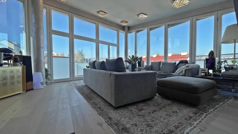 Helles Wohnzimmer mit großen Fenstern, die viel Tageslicht hereinlassen und einen weiten Blick bieten.