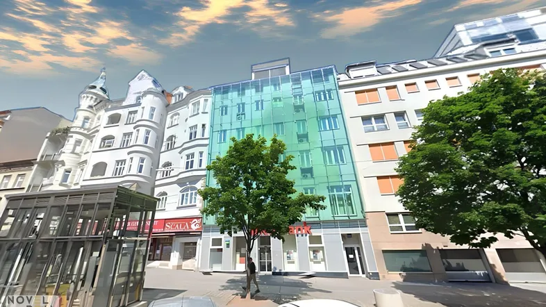 Moderne Gebäudefassade mit Glasfront und traditionellen Nachbargebäuden in urbaner Umgebung.