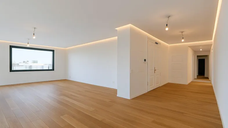 Heller, leerer Raum mit Parkettboden und großen Fenstern, ideal für einen Wohnbereich.