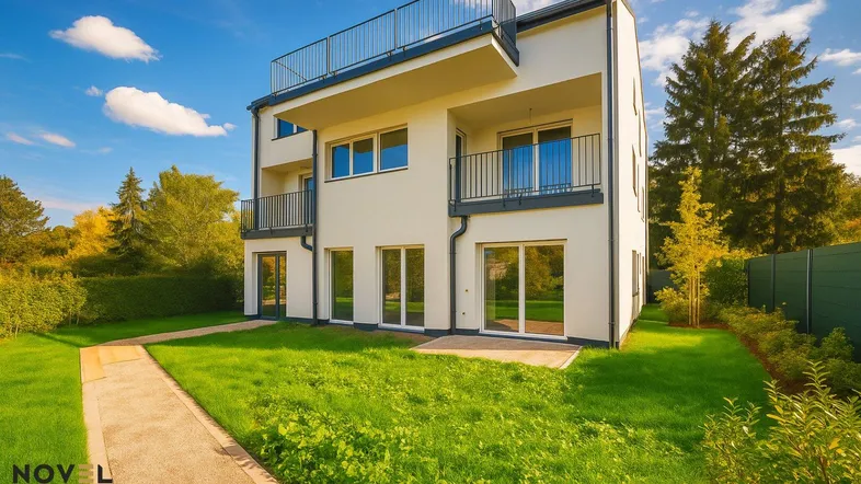 Modernes Mehrfamilienhaus mit weißer Fassade, Balkonen, Dachterrasse und gepflegtem Gartenbereich.