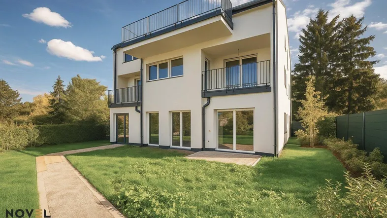Modernes Mehrfamilienhaus mit weißer Fassade, Balkonen und einem gepflegten Vorgarten.