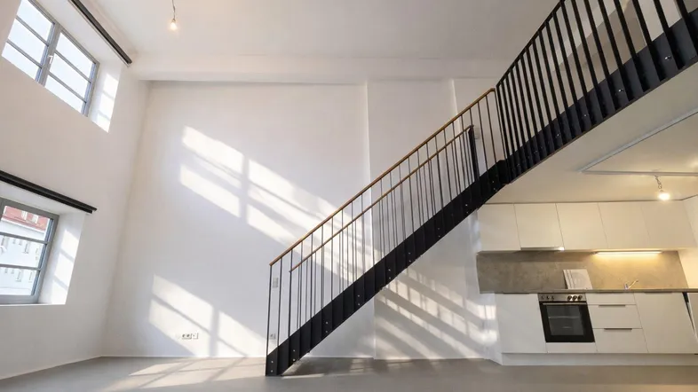 Helles, offenes Loft mit hohen Decken, moderner Küche und Treppe zur Galerie.