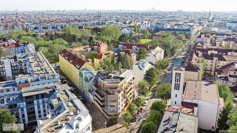 Luftaufnahme der Stadt mit dem neuen Wohngebäude und umliegender Bebauung.