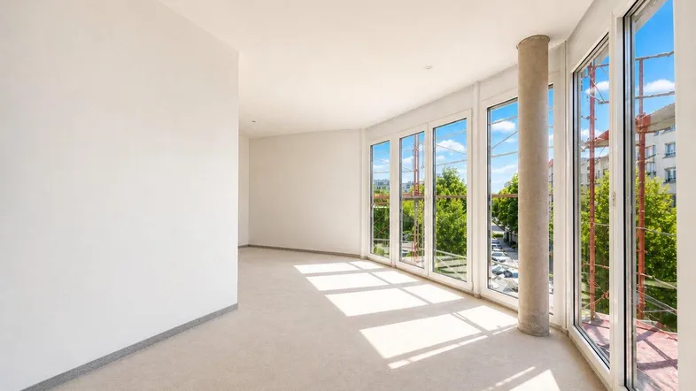 Helles, unmöbliertes Zimmer mit großen Fenstern und viel Tageslicht, bereit für den Ausbau.