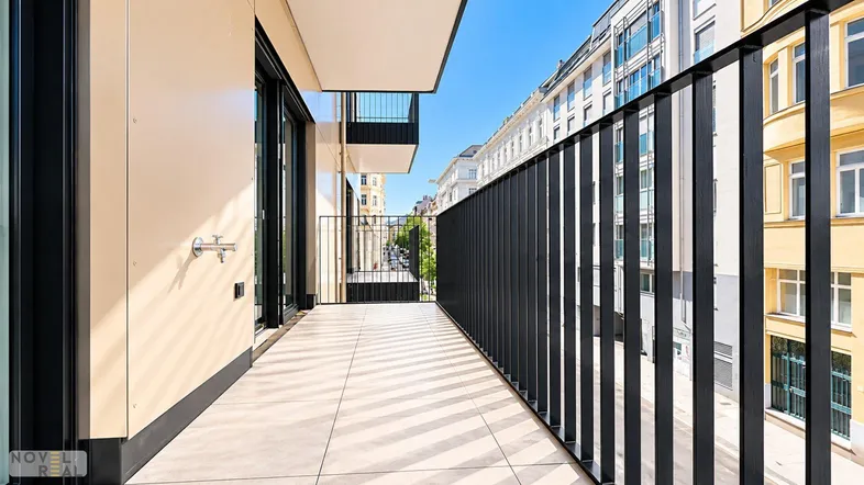 Langer, schmaler Balkon mit Fliesenboden und Blick auf die Stadtstraße.