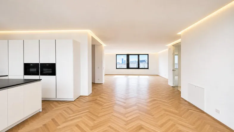 Heller, offener Wohn- und Essbereich mit moderner Einbauküche, Fischgrätparkett und Stadtblick.