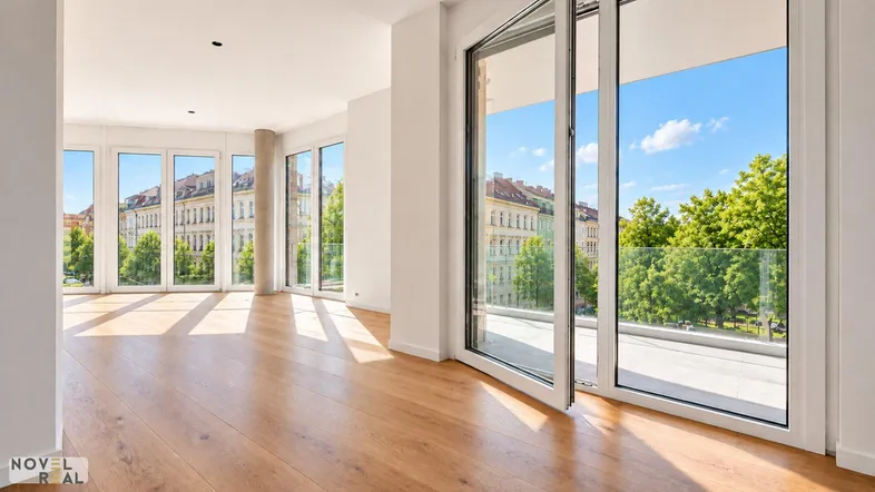 Helles Wohnzimmer mit großen Fenstern, Holzboden und Zugang zu einem Balkon mit Stadtblick.