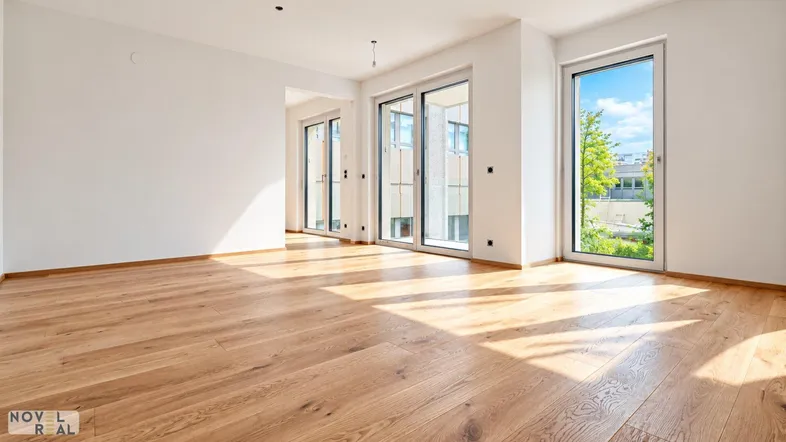 Helles, leeres Zimmer mit Eichenparkett und großen Fenstern, die viel Tageslicht hereinlassen.