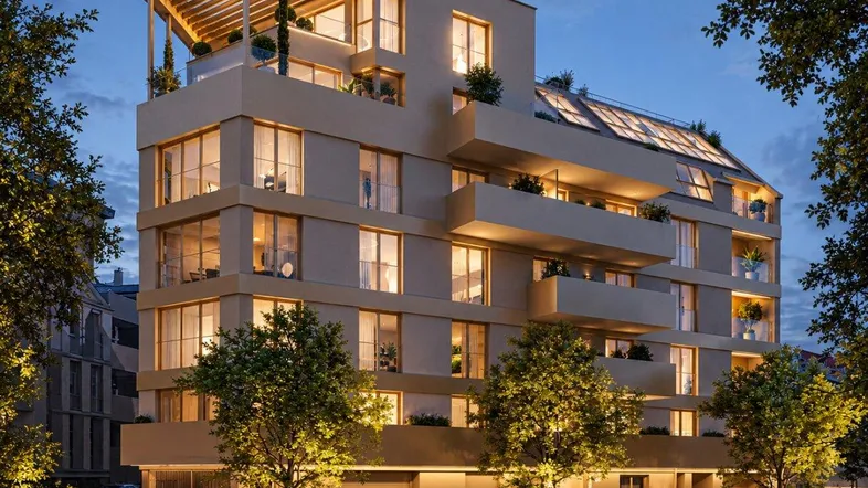 Moderne Wohnanlage bei Nacht mit beleuchteten Balkonen und Dachterrassen, umgeben von Bäumen.
