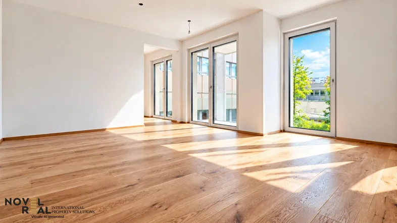 Helles, leeres Zimmer mit Holzboden und großen Fenstern, die viel Tageslicht hereinlassen.