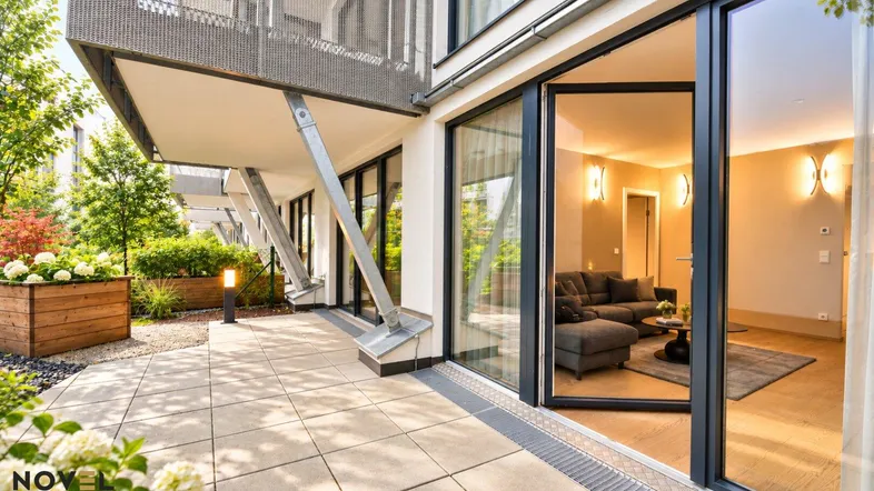 Große, geflieste Terrasse mit Pflanzenkübeln und direktem Zugang zum hellen Wohnbereich.