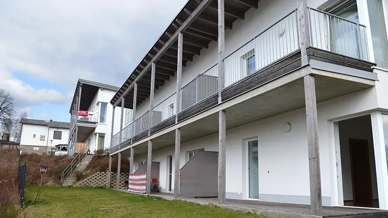 Moderne Wohnanlage mit mehreren Balkonen und Grünflächen.