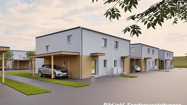 Moderne Reihenhäuser mit Carports und gepflegten Grünflächen in einer Wohnsiedlung.