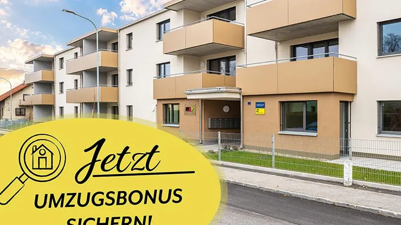 Modernes Mehrfamilienhaus mit hellen Fassaden und mehreren Balkonen unter blauem Himmel.